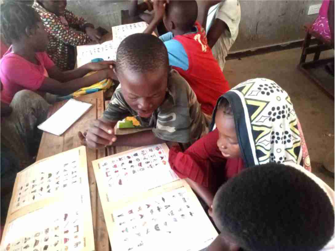 Children in a partner classroom studying with ALfA literacy workbooks during a Rapid Results Initiative